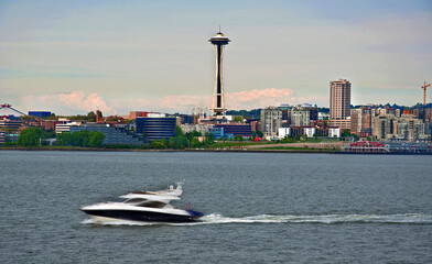 A speedboat is rushing by in the foreground of this cityscape of a skyline of Seattle, Washington,...