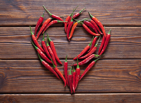 background of fresh red chili pepper arranged into heart shape for love