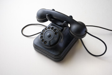 old 1950s bakelite telephone of 3/4 left on white background