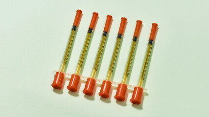Top view of insulin syringes for diabetes lying isolated over light background. Injection medicine concept