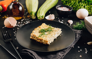 Zucchini casserole on dark background. Dietary, low-calorie, healthy food. Homemade Casserole from squash with chicken and eggs.