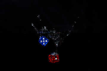 Blue and red dice dropped into water