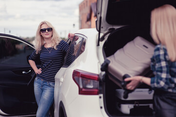 Two young women are going to travel by car