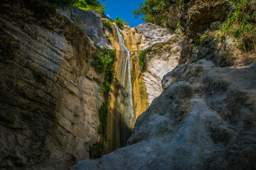 Small waterfall running through large rocks in Lefkada, Greece