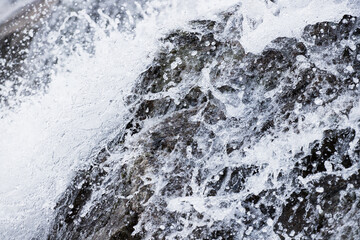 Close up of a mountain waterfall and water bumping into the rocks.