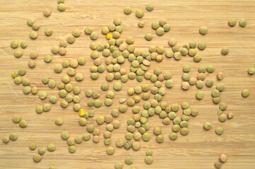 Green lentil grains on bamboo cutting board