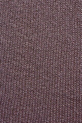 Knitted mauve background. Knitted purple textiles for text. The texture of a wool sweater. Hand knitting. Machine knitting. Purple, violet, lavender.