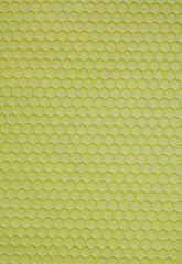 Plastic background in the form of salad-colored honeycombs. Textured corrugated background of salad color. Monotonous corrugated texture for an abstract background or for wallpaper.