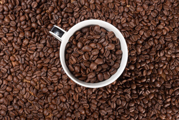 coffee beans overflowing from a beautiful cup