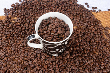coffee beans overflowing from a beautiful cup