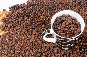 coffee beans overflowing from a beautiful cup