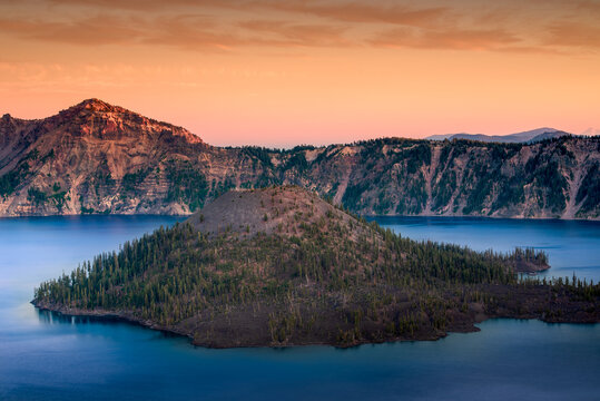 beautiful sunset at crater lake in Oregon with blue water and tree