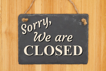 Sorry we are closed type message on a hanging chalkboard sign