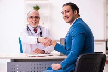 Fototapeta na wymiar Young businessman meeting with old doctor