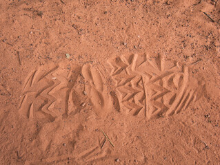 Einzelner Schuhabdruck im Sand auf einem Wanderweg