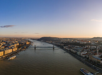 Aerial drone shot of Danube river with chain bridge and Buda Castle in Budapest in Sunset hour