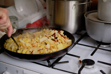 fried potatoes on the stove in the pan
