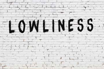 Word lowliness painted on white brick wall - obrazy, fototapety, plakaty