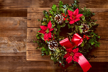 Amazing Christmas wreath with big red bow, Red Christmas Poinsettia flowers and Holly Berries on...