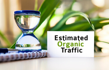 Organic traffic - business concept text on a white notebook and hourglass clock, green leaves of...