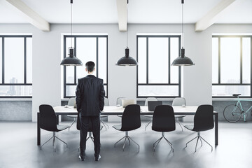 Businessman standing in loft office interior