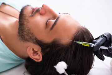 Fototapeta premium Young man visiting female beautician in hair transplantation con