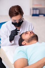 Young man visiting female beautician in hair transplantation con