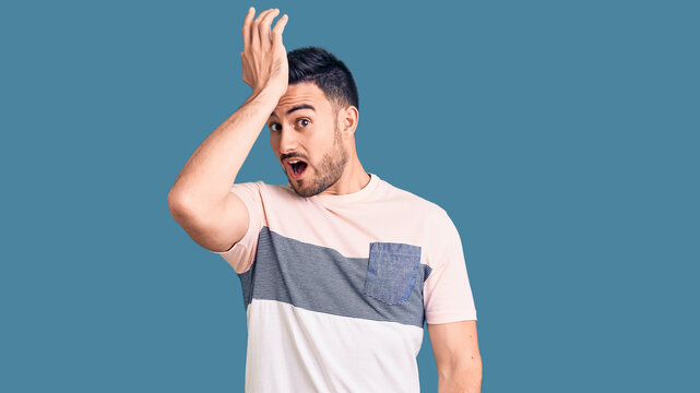 Young handsome man wearing casual clothes surprised with hand on head for mistake, remember error. forgot, bad memory concept.