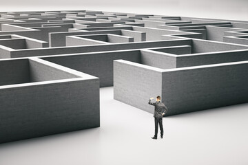 Businessman standing at entrance to a gray maze.