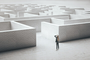 Businesswoman standing at entrance to a white brick maze.