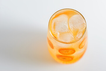 Kumquat lemonade in the glass on the white background.