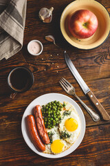 Breakfast with fried eggs, sausages and green peas