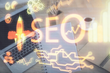 Double exposure of woman hands working on computer and seo hologram drawing. internet search concept.