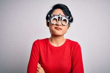 Young beautiful asian girl wearing optometry glasses standing over isolated white background skeptic and nervous, disapproving expression on face with crossed arms. Negative person.