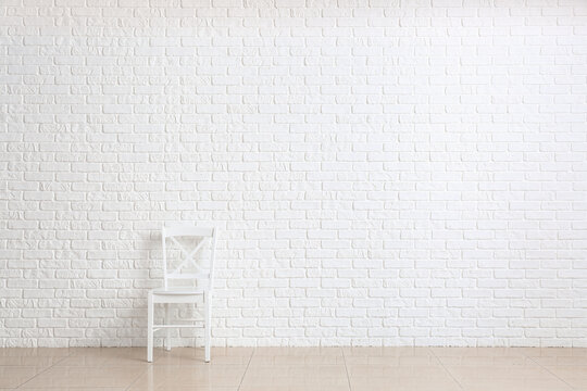 Chair Near White Brick Wall In Room