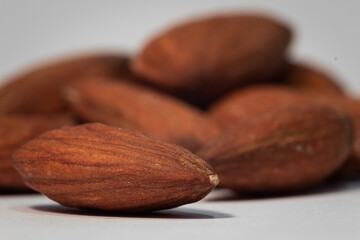 A macro shot of an almond in front of a pile