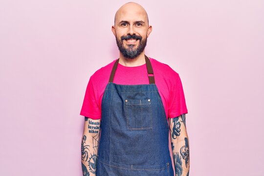 Young handsome man wearing apron with a happy and cool smile on face. lucky person.