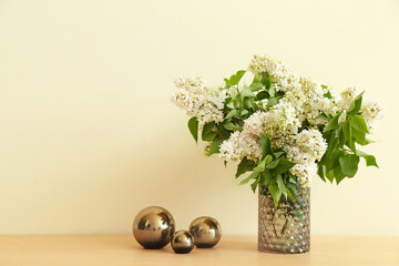 Vase with beautiful flowers on table near color wall