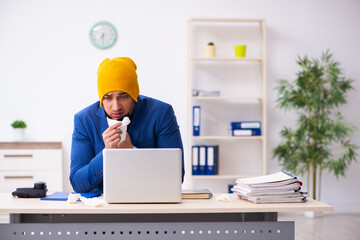 Sick male employee suffering at workplace from coronavirus