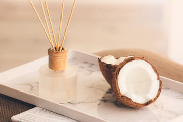 Reed diffuser and coconut on table in room