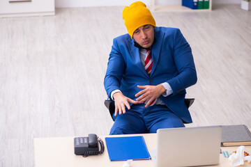Sick male employee suffering at workplace from coronavirus