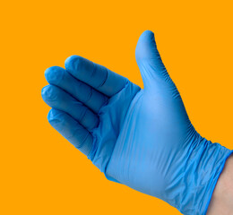Half open hand, with a blue glove and with a yellow background. Concept of approach, order.