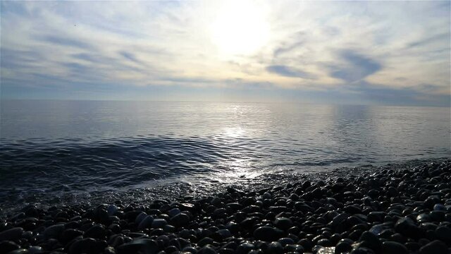 waves lapping in the evening calm sea at sunset.
