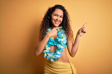Young beautiful american woman on vacation wearing bikini and hawaiian lei flowers smiling and...