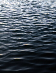 Rippled surface of water. Graduated blue, pink and white water surface with wavelet patterns.