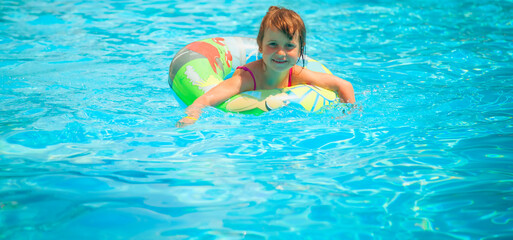 Pretty little child girl in the outdoor pool. Horizontal image.