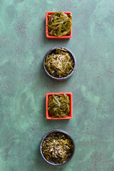 Bowls with tasty seaweed on color background