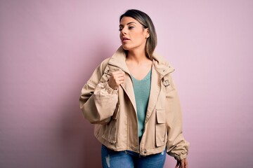 Young beautiful woman wearing fashion urban clothes, model wearing casual street style standing over pink background