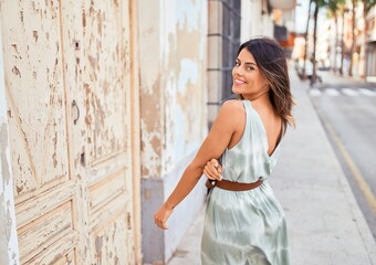 Fototapeta premium Beautiful young woman wearing fashionable clothes walking down the street