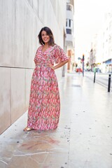 Beautiful young woman wearing fashionable clothes walking down the street